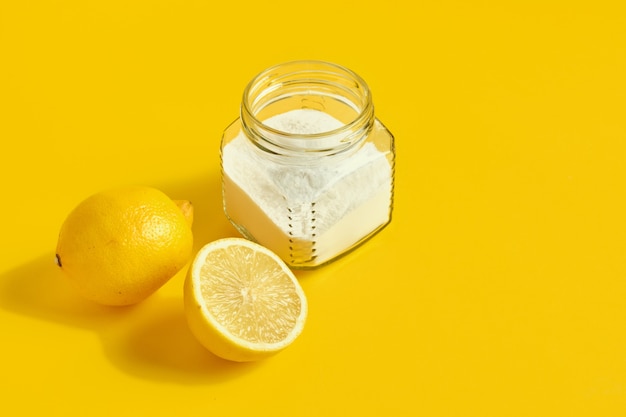 refresco y limón sobre fondo amarillo concepto de limpieza ecológica