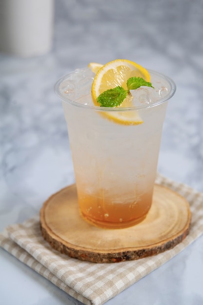 Refresco de miel y limón con hielo en vidrio plástico.