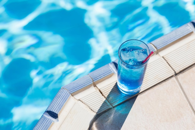 Refrescos de verano Cóctel laguna azul con hielo cerca de la piscina en un día soleado