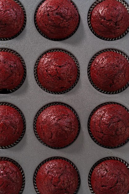 Refrigeración de cupcakes de terciopelo rojo recién horneados en un mostrador de cocina