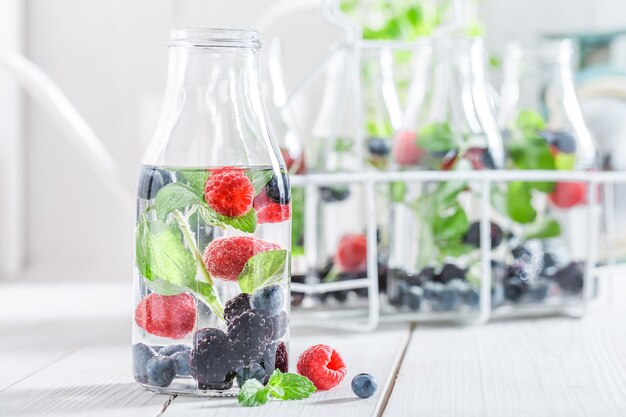 Refrigerante em garrafa com frutas na mesa branca