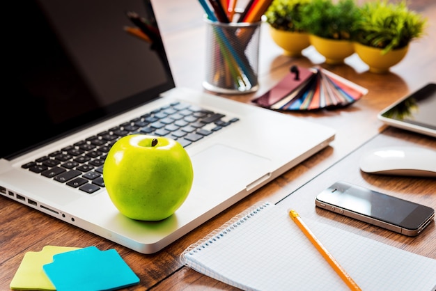 Refrigerio para la productividad empresarial. Primer plano de un cómodo lugar de trabajo en la oficina con mesa de madera y portátil tendido sobre él