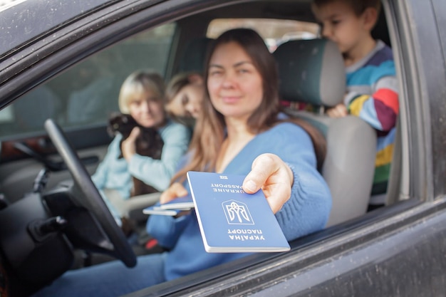 Foto refugiados ucranianos huyendo de la guerra contra rusia madre muestra pasaportes en la frontera