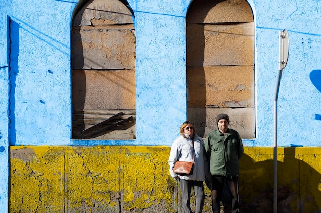 Refugiados ucranianos idosos ao lado de um prédio em ruínas