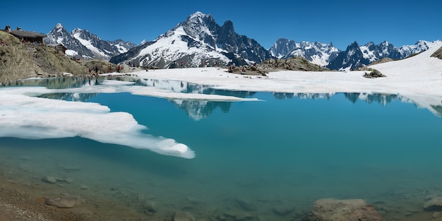 Refugio en alta montaña con lago deshielo frente al Mont Blanc en los Alpes