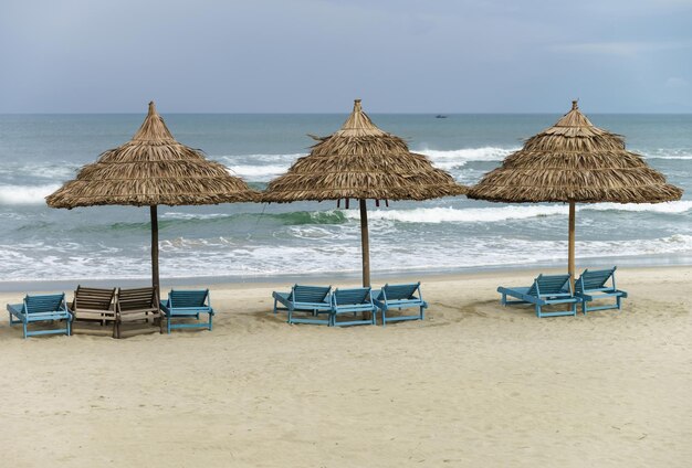 Refugio de palmeras y tumbonas en China Beach en Da Nang, en Vietnam. También se la llama Playa Non Nuoc. Mar de China Meridional en el fondo.