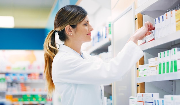 Regal für Apothekenprodukte und glückliche Apothekerin oder Chemikerin auf der Suche nach Pillen, Nahrungsergänzungsmitteln oder Pharmazeutika. Krankenhaus-Einzelhandelsapotheke für Medikamente und medizinische Person, die Box-Paket-Display repariert