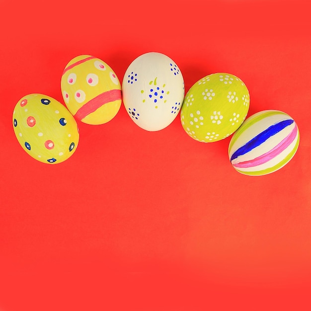 Regala huevos de Pascua sobre un fondo rojo, el símbolo de las vacaciones.
