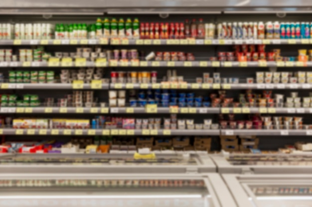 Regale mit einer Vielzahl von Milchprodukten im Supermarkt. Verschwommen. Vorderansicht.