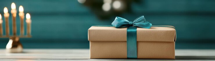 regalo bellamente envuelto con cinta azul azul se sienta en una mesa de madera evocando una atmósfera cálida y festiva el suave resplandor de las velas en el fondo mejora el espíritu navideño