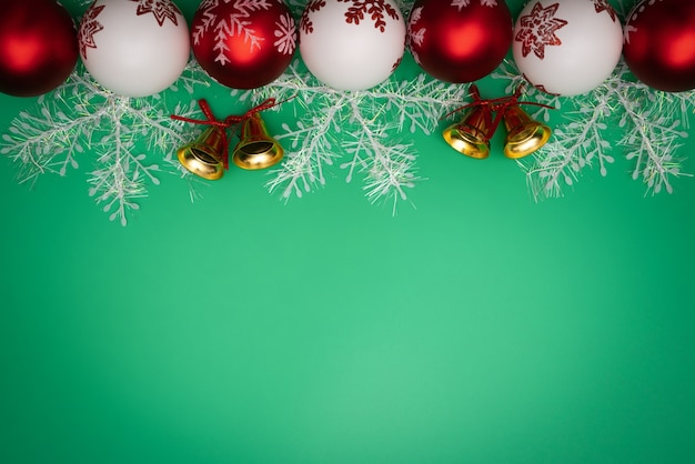 Regalo, campana y bola de la Navidad en fondo verde. Colocación plana, vista superior
