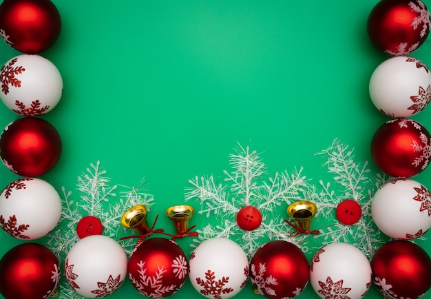 Regalo, campana y bola de la Navidad en fondo verde. Colocación plana, vista superior