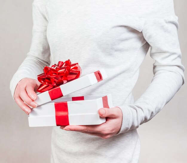 Regalo con cinta roja en manos femeninas