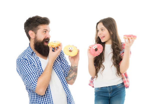 Regalo del día del padre Perfecto para papás golosos Niña y papá sostienen donas glaseadas de colores Concepto de dulces y golosinas Hija y padre comen donas dulces Postre dulce Nos encantan las donas