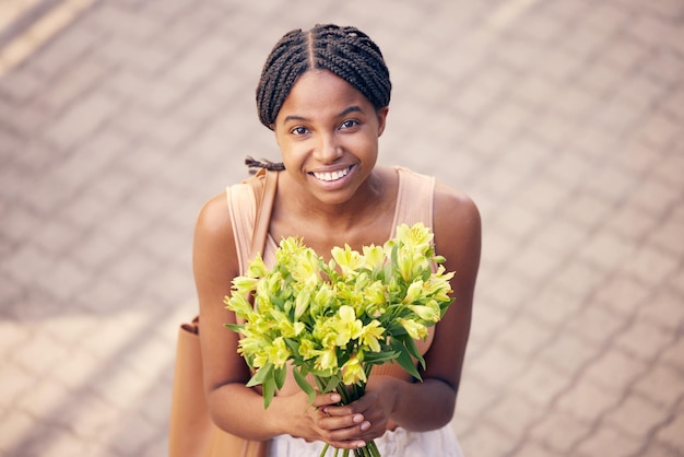 Regalo de flores y mujer negra con sonrisa para ramo de cumpleaños o celebración en la calle desde arriba Cara de una niña africana con un regalo de lirios amarillos en la carretera y la ciudad de Francia