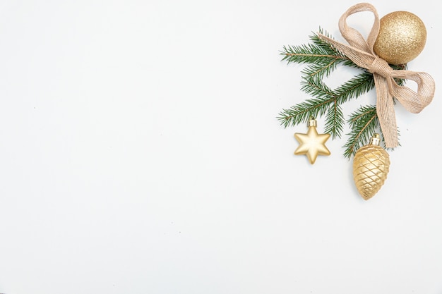Regalo de Navidad con arco de bolas de oro aislado sobre fondo blanco.
