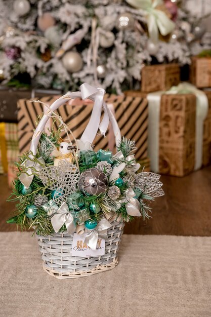 Regalo de Navidad como composición mágica con cesta. bolas de colores, piñas, dulces, ramas de abeto, nueces y copos de nieve. Estilo rústico. decoración festiva cesta de mimbre de navidad