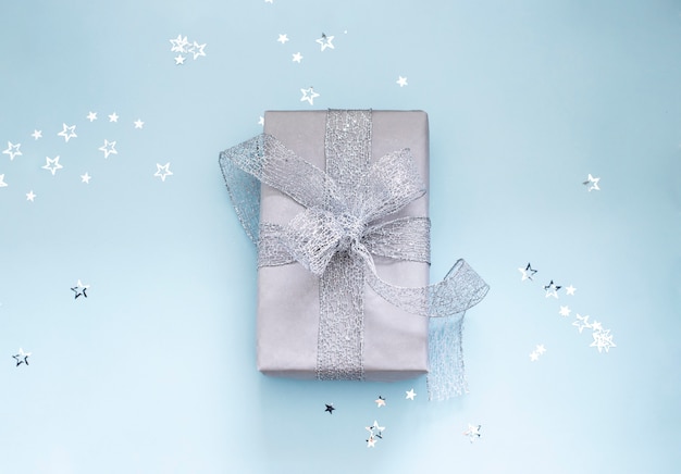 regalo de navidad envuelto con cinta plateada en azul claro