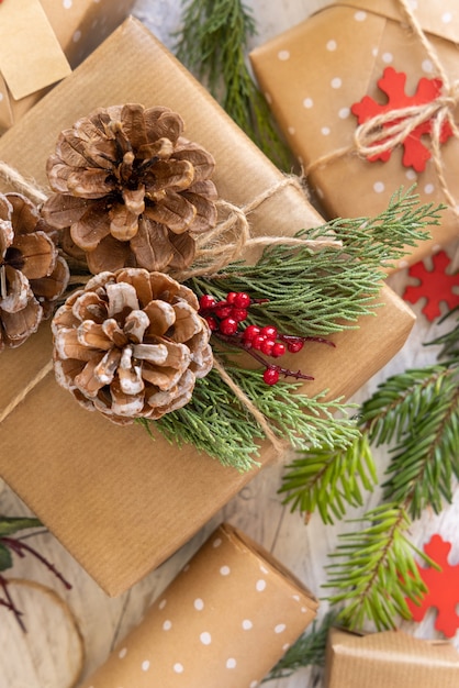 Regalo de Navidad envuelto decorado con piñas y ramas de enebro