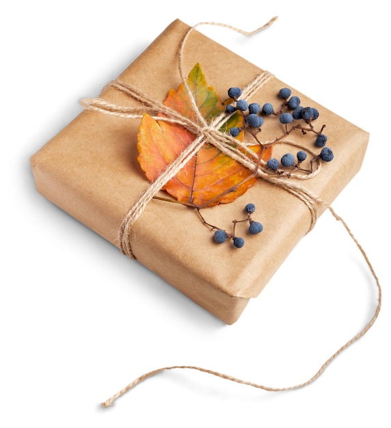 Regalo de Navidad. Hojas naturales de otoño y papel kraft como decoración.