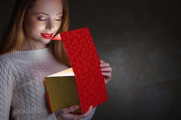 Regalo de Navidad Magia de vacaciones. Niña feliz abriendo una caja de regalo