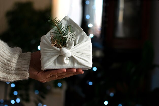 Regalo de Navidad en las manos. Embalaje en materiales ecológicos