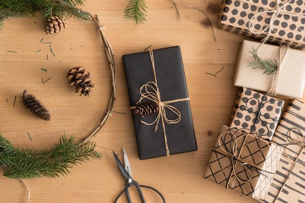 Regalo de navidad negro con una corona de navidad y regalos en una mesa de madera