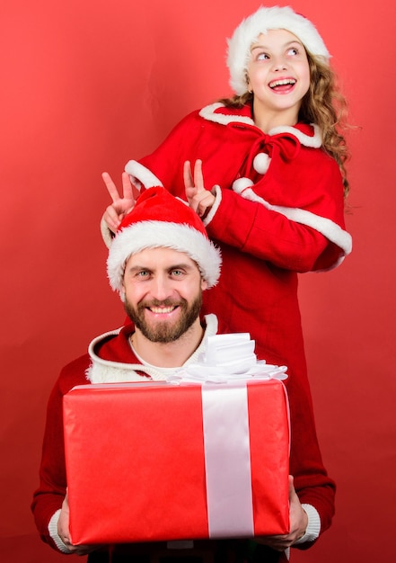 Regalo de Navidad para niño. Papá en traje de santa y niño lindo hija. Infancia feliz. Vacaciones familiares de Navidad. Concepto de Papá Noel. Haz que las vacaciones sean muy especiales. Celebren la Navidad juntos.