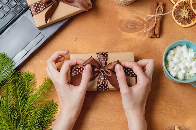 Regalo de Navidad o caja de regalo envuelta en papel kraft sobre decoración navideña