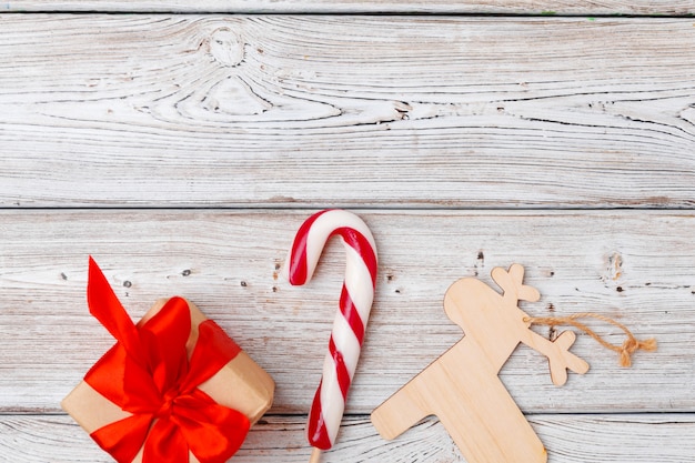 Regalo de Navidad rojo con decoraciones sobre fondo de madera