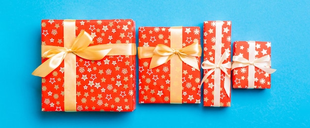 Regalo de Navidad u otro regalo de vacaciones hecho a mano en papel con cinta dorada sobre fondo azul