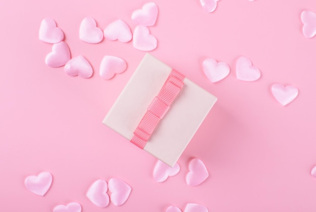 Regalo o caja de regalo, corazones rosas en la vista superior de la mesa rosa. Composición plana para el día de San Valentín, cumpleaños, día de la madre o boda, monocromo, enfoque selectivo