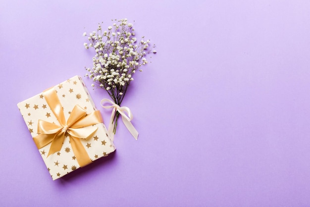 Regalo o caja de regalo y gypsophila de flores en la vista superior de la mesa de luz Tarjeta de felicitación Estilo plano con espacio de copia