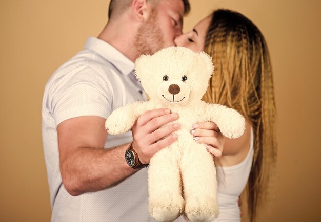 Regalo de osito de peluche Chico y chica caricias Familia feliz Día de San Valentín Concepto de embarazo Hombre y mujer pareja enamorada Futuros padres Amor familiar Hombre y niña bonita enamorados