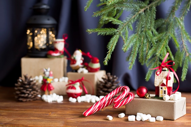 Un regalo con paletas de rayas y un juguete de Navidad sobre un fondo de Navidad