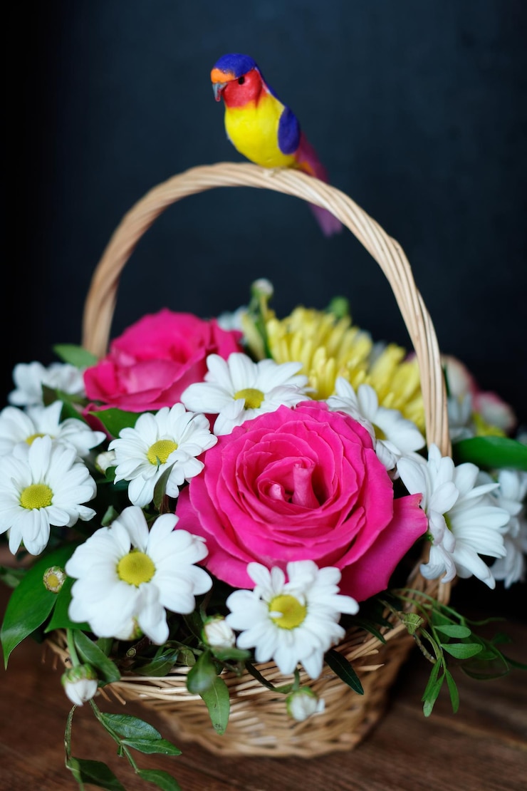 Foto regalo ramo de flores en una cesta de mimbre con asa sobre un fondo oscuro