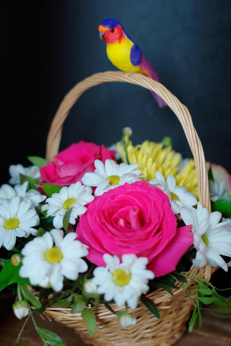 Foto regalo ramo de flores en una cesta de mimbre con asa sobre un fondo oscuro