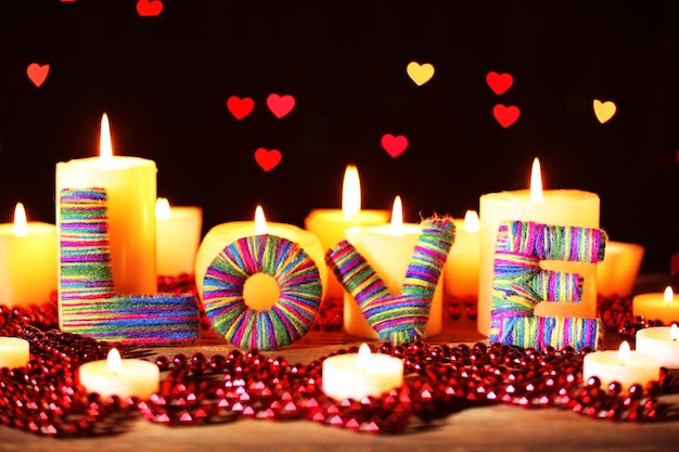 Regalo romántico con velas sobre fondo de luces, concepto de amor