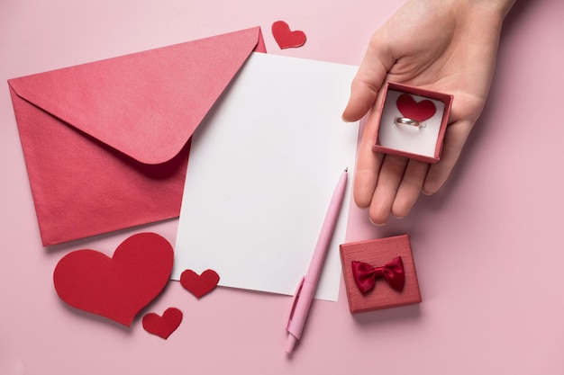 Foto regalo de san valentín en la caja carta y sobre con espacio de copia en fondo rosa anillo para