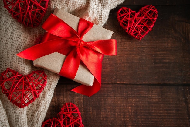 Regalo de San Valentín en una caja con una cinta roja sobre un fondo marrón