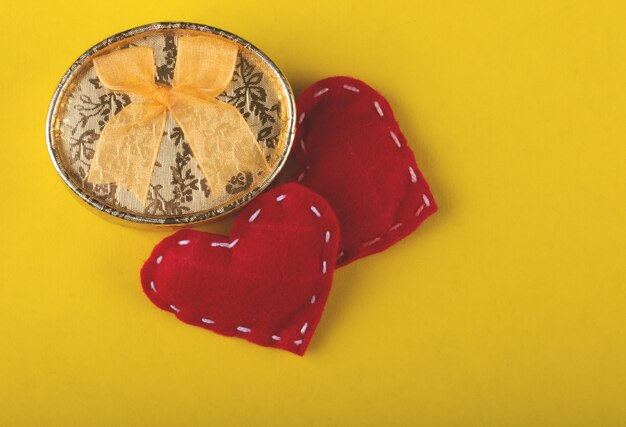 Regalo de San Valentín con corazones rojos sobre fondo amarillo.