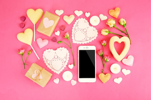 Regalo de san valentín con dulces y decoración en la vista superior de fondo rosa