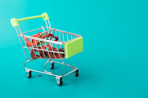 Regalos de amor del día de San Valentín, muchos corazones en un carrito de compras del supermercado sobre un fondo verde con espacio de copia