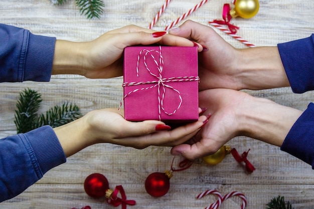 Regalos de año nuevo en manos sobre un fondo de madera. Enfoque selectivo de Navidad