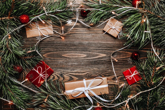 Regalos de año nuevo sobre fondo de madera con árbol de navidad y juguetes