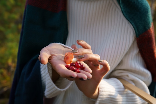 Regalos de arándanos y setas de otoño en la mano femenina actividad de ocio de caminar en el bosque de otoño