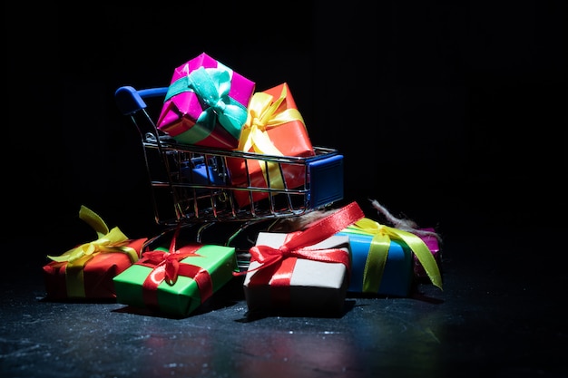 Regalos en cajas de colores en un carrito de compras. De cerca