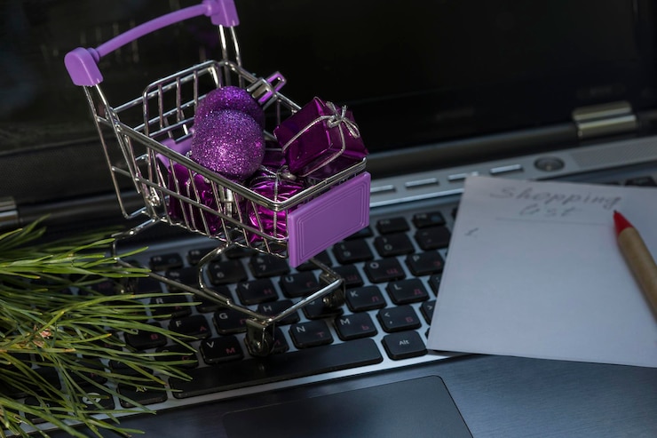 Foto regalos de compras navideñas en línea en el carrito de compras en el teclado de la computadora portátil