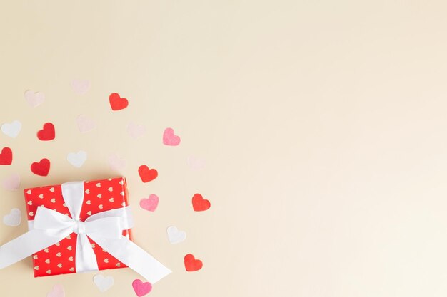 Regalos conceptuales para sus seres queridos para el día de San Valentín Día de la mujer Día de la madre o cumpleaños Caja de regalo envuelta en rojo Corazones alrededor