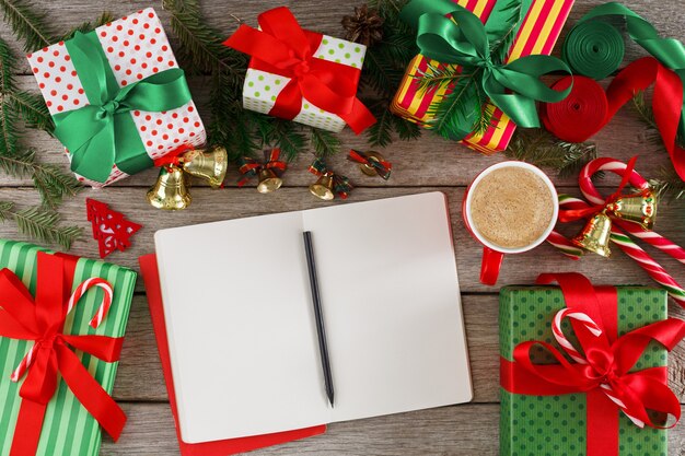 Foto regalos para cualquier fondo de vacaciones. cajas de regalo coloridas y cuaderno abierto para lista de compras con espacio de copia en madera rústica, vista superior. preparándose para la celebración de navidad, año nuevo o cumpleaños.